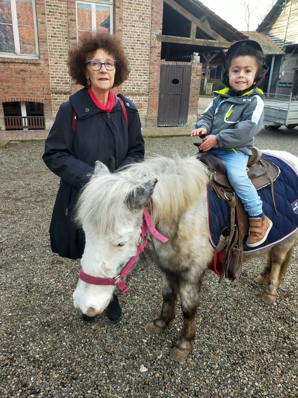 Adao sur un poney avec Chantal a ses côtés